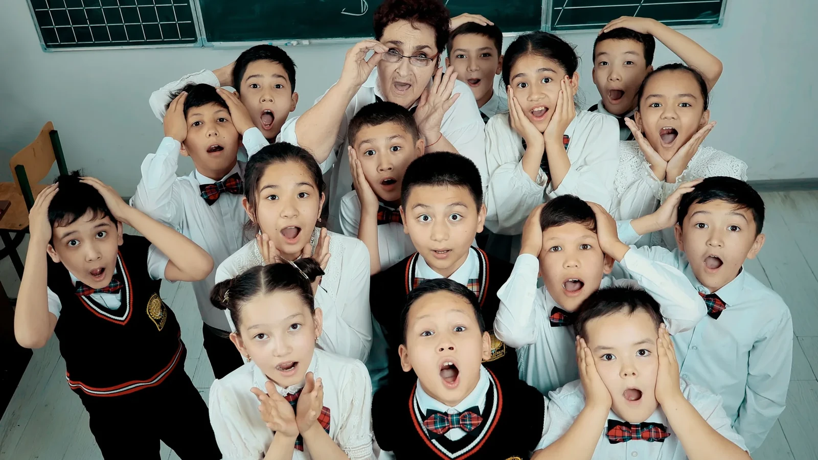 A group of school learners celebrating together in a classroom