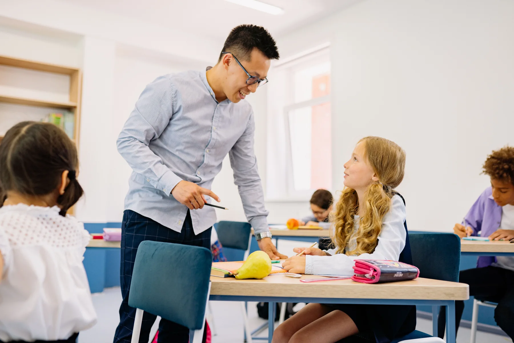 Teacher supporting a student in a classroom